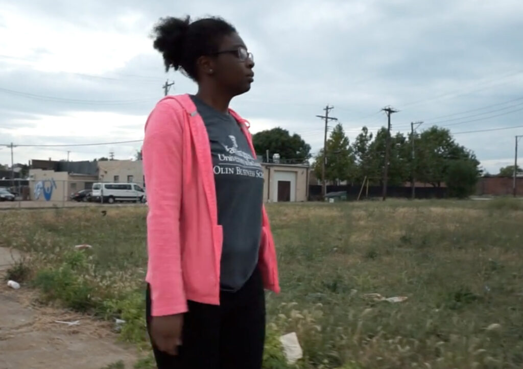 Jaliece, a young woman stands in an empty city lot