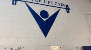 Lift for life gym logo painted on white interior brick wall