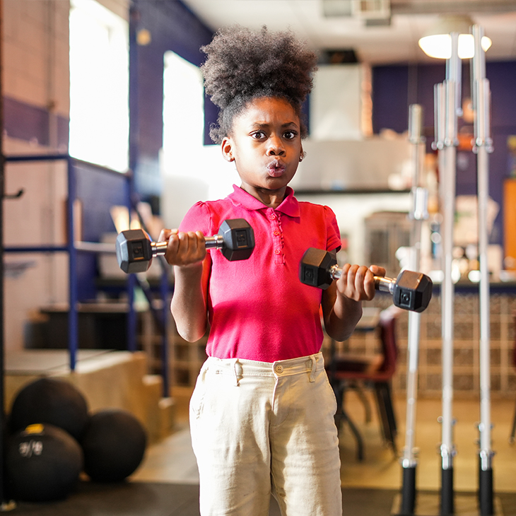 young girl lifting hand weights