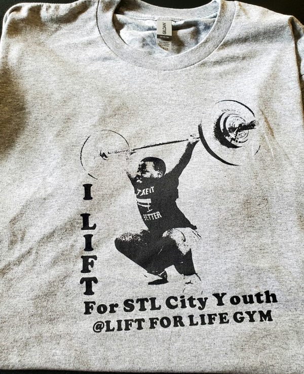 white shirt with weight lifter illustration and the words I lift for STL City Youth